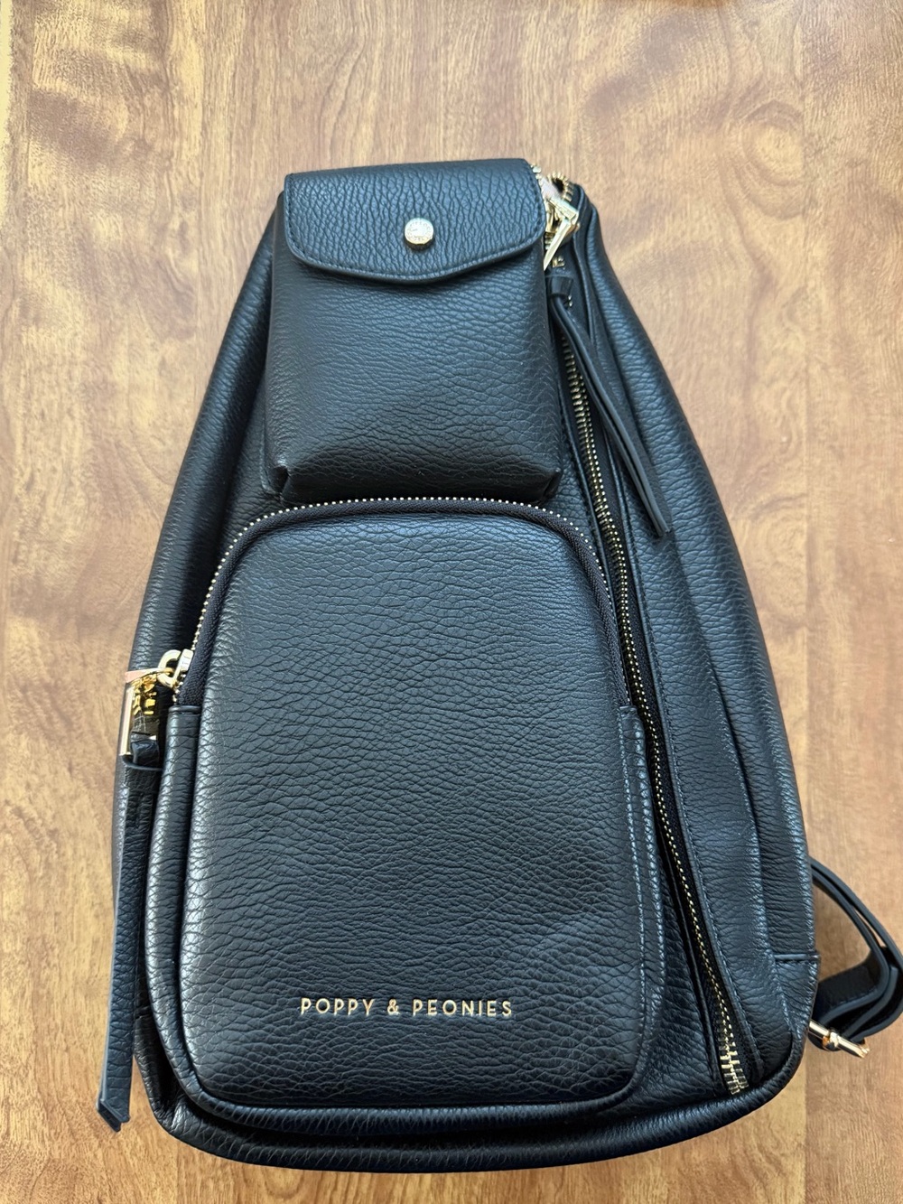 Poppy & Peonies Black Pebbled Leather En Route Sling Bag with Gold Hardware.